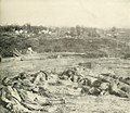 Confederate dead lay gathered at the bottom of the parapet of Battery Robinett on the day after the Battle of Corinth. Col. William P. Rogers of the 2nd Texas (on the very left) seized his colors to keep them from falling again and jumped a five foot ditch, leaving his dying horse and assaulted the ramparts of the battery. When canister shot killed him, he was the fifth color bearer to fall that day. Note: This text erroneously reports that his second-in-command, Col. Lawrence Ross lays beside him. In fact, Ross went on to become a general and later the governor of Texas. He died in 1898.