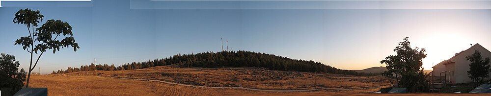 תמונה פנורמית של תל טוואני - מצולם ממעון. בשני צדי התמונה בתים במעון.