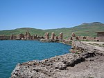 Ruins of buildings near a lake.