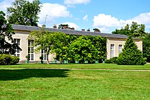 L'Orangerie à l'arrière d'un parterre de verdure.