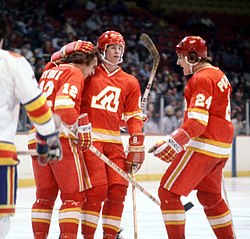 Two Atlanta players (Lysiak and Shand) embrace following a goal as Phillipoff skates in to join them.