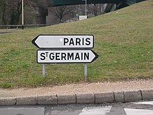 Sur une route, deux panneaux directionnels indiquent les villes de Paris et de Saint-Germain