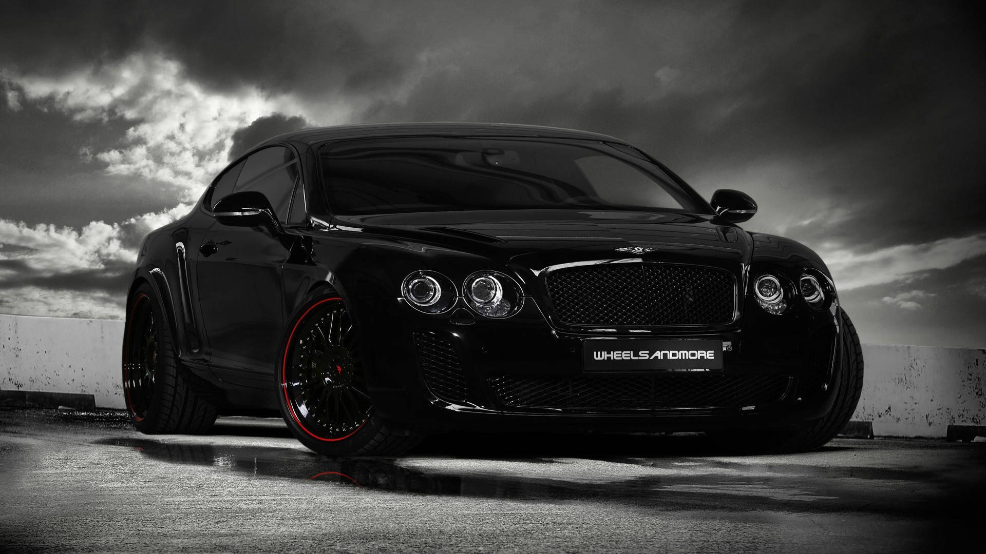 Schwarzer Bentley Sportwagen mit roten Rädern auf nassem Asphalt unter Sturmwolken. — Schwarze Sportwagen Wallpaper