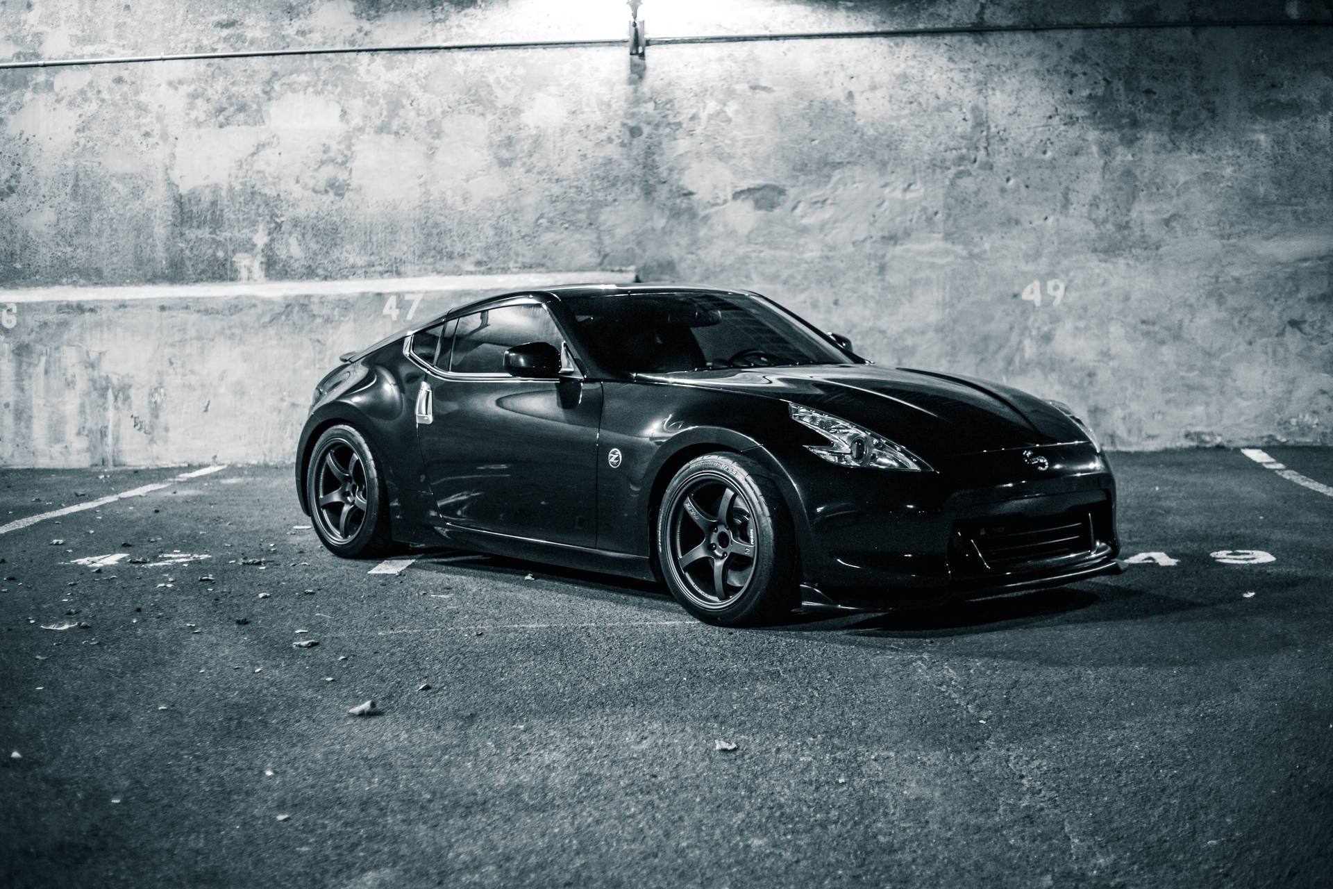 Schwarzes Sportauto geparkt in einer Betongarage mit nummerierten Linien. — Schwarze Sportwagen Wallpaper
