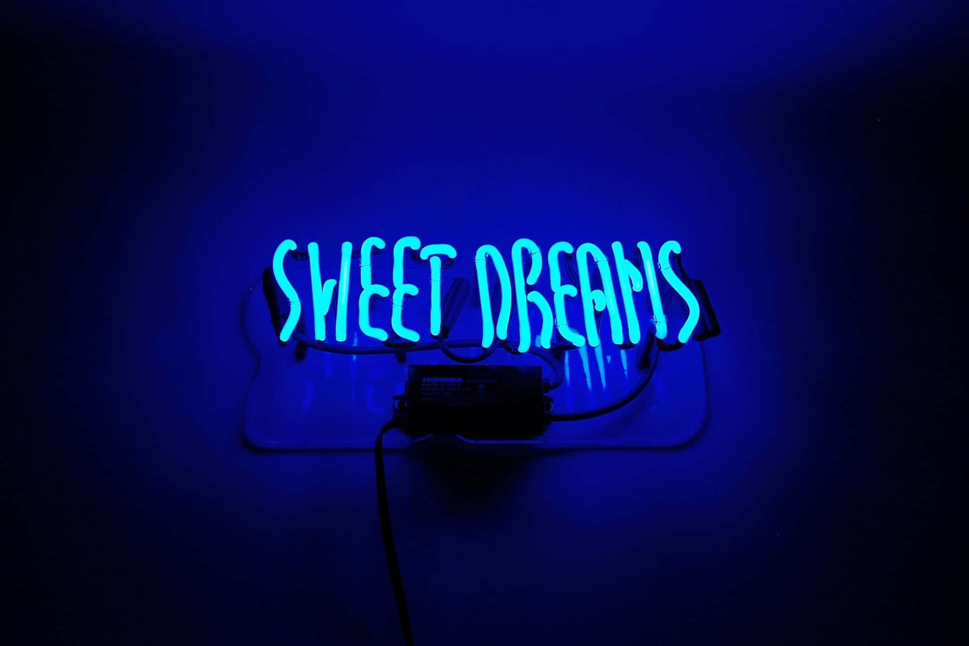 Une enseigne au néon avec la phrase "Sweet Dreams" brille en bleu sur un fond sombre, projetant une lumière douce sur le mur. — Esthétique Bleue Néon Fonds d'écran