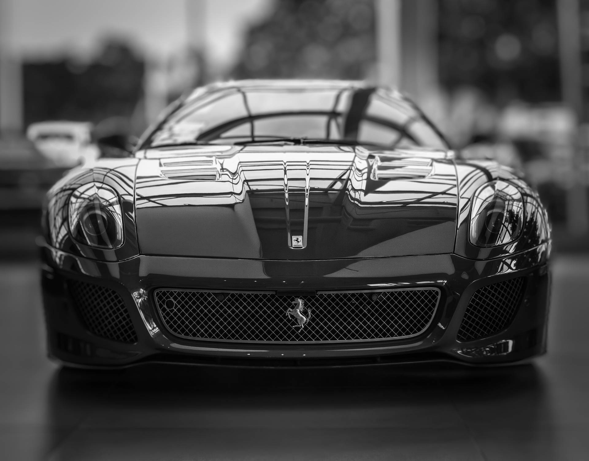 Frontansicht eines schwarzen Ferrari-Sportwagens in einem Ausstellungsraum mit reflektierenden Oberflächen. — Schwarze Sportwagen Wallpaper