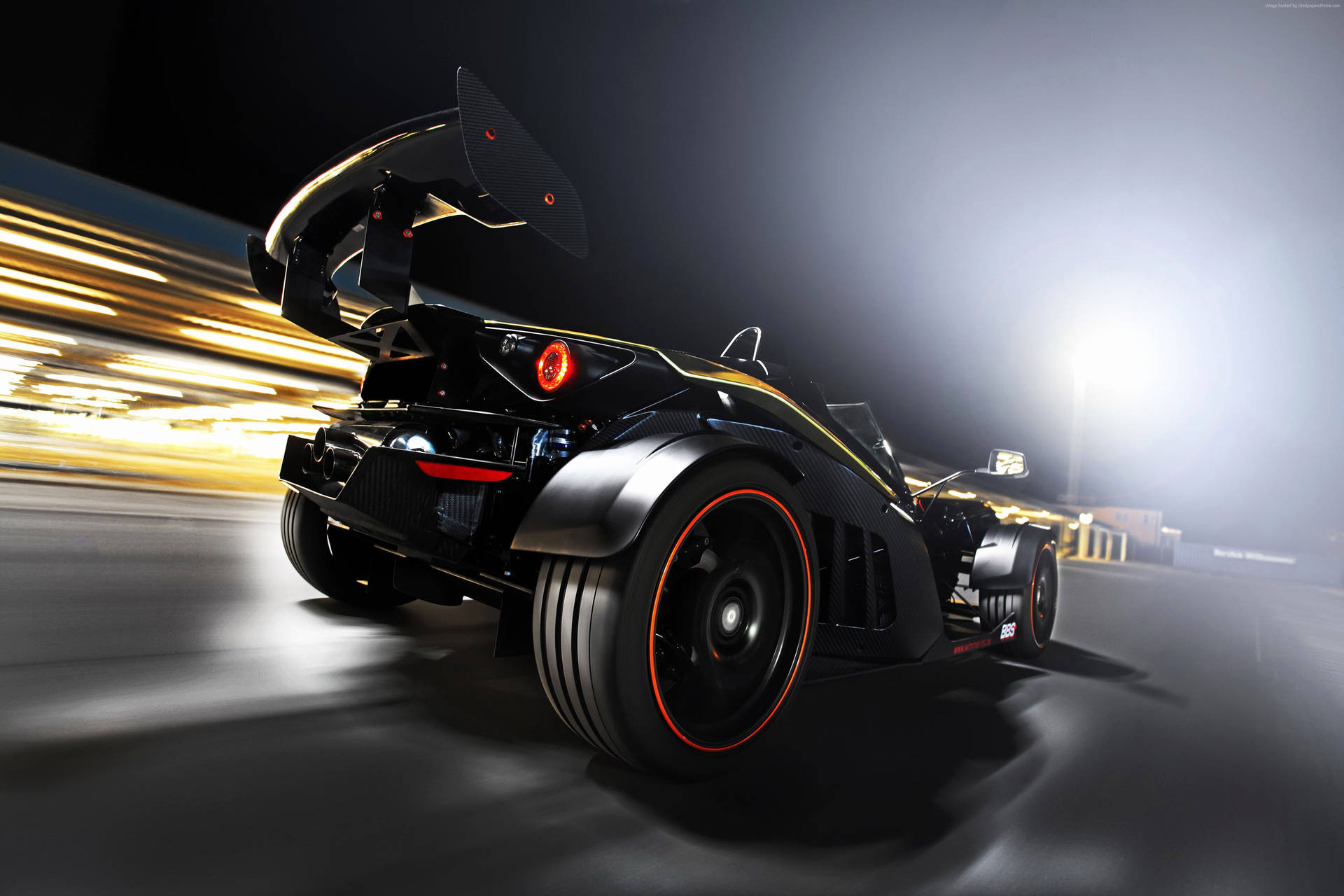 Schwarz-goldener Sportwagen, der nachts auf einer Rennstrecke mit Bewegungsunschärfe rast. — Schwarze Sportwagen Wallpaper