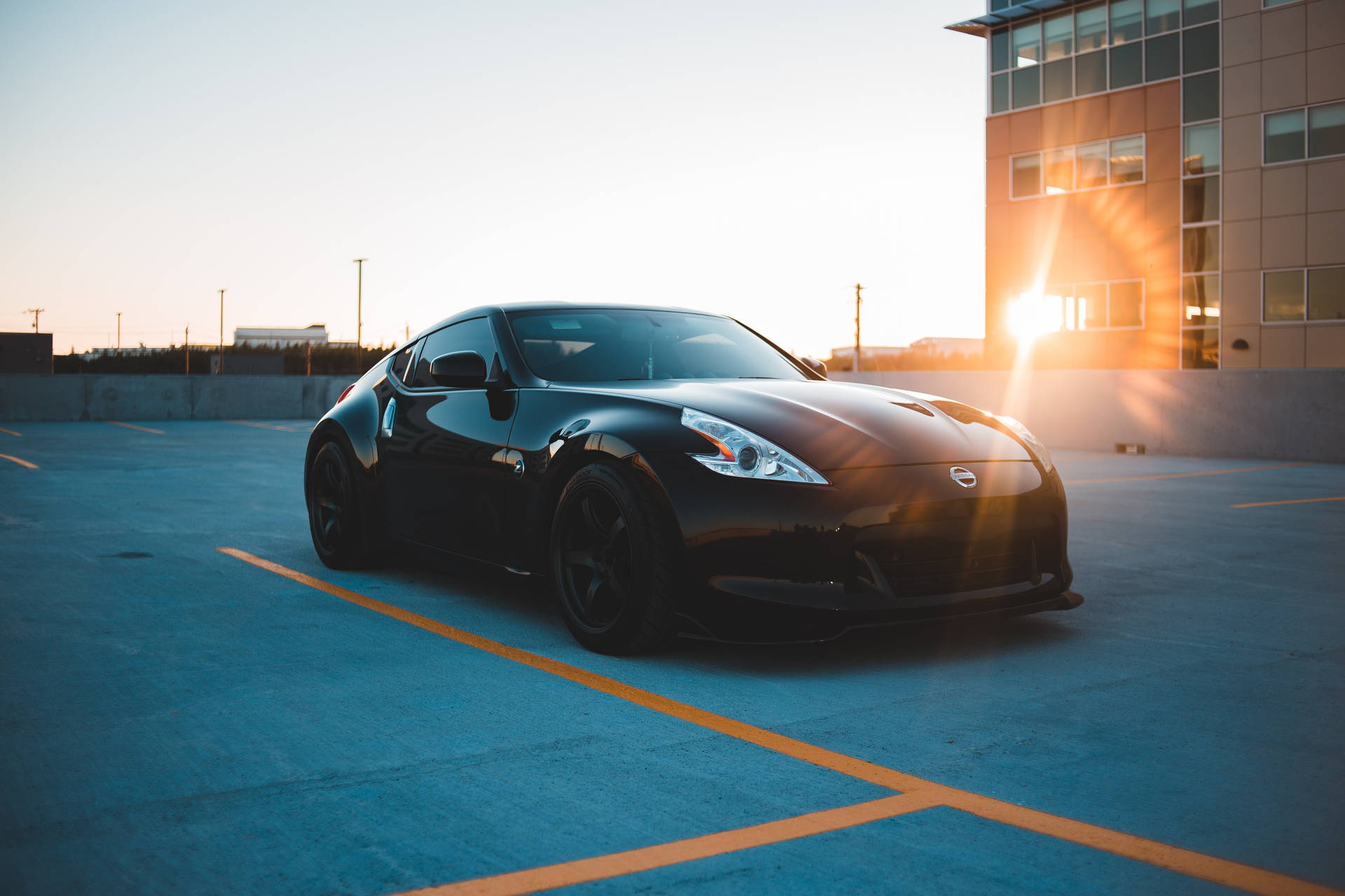 Schwarzes Sportauto geparkt auf städtischem Parkplatz bei goldenem Sonnenuntergang. — Schwarze Sportwagen Wallpaper
