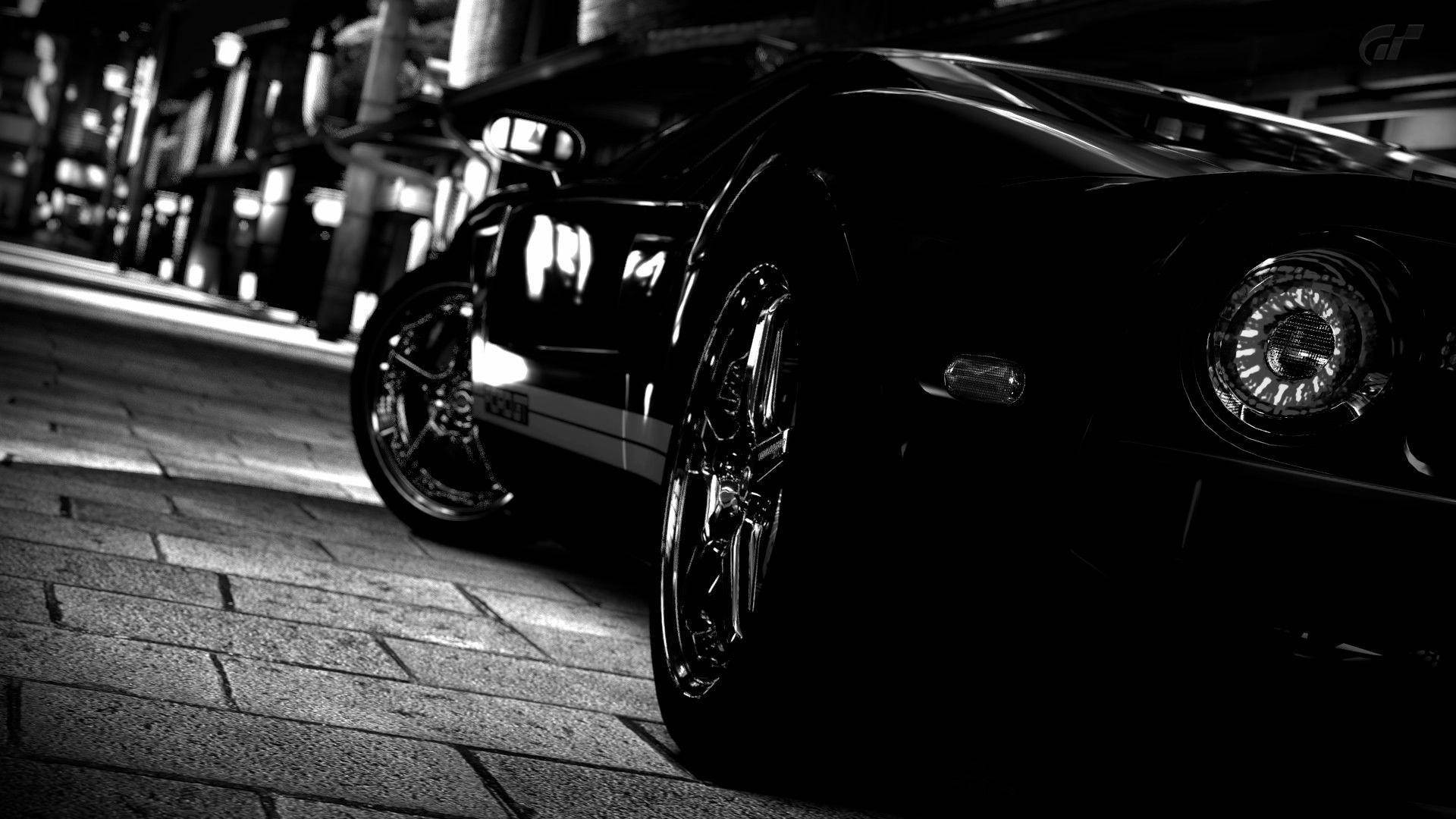 Schwarzer Sportwagen geparkt auf Kopfsteinpflasterstraße bei Nacht mit dramatischer Beleuchtung. — Schwarze Sportwagen Wallpaper