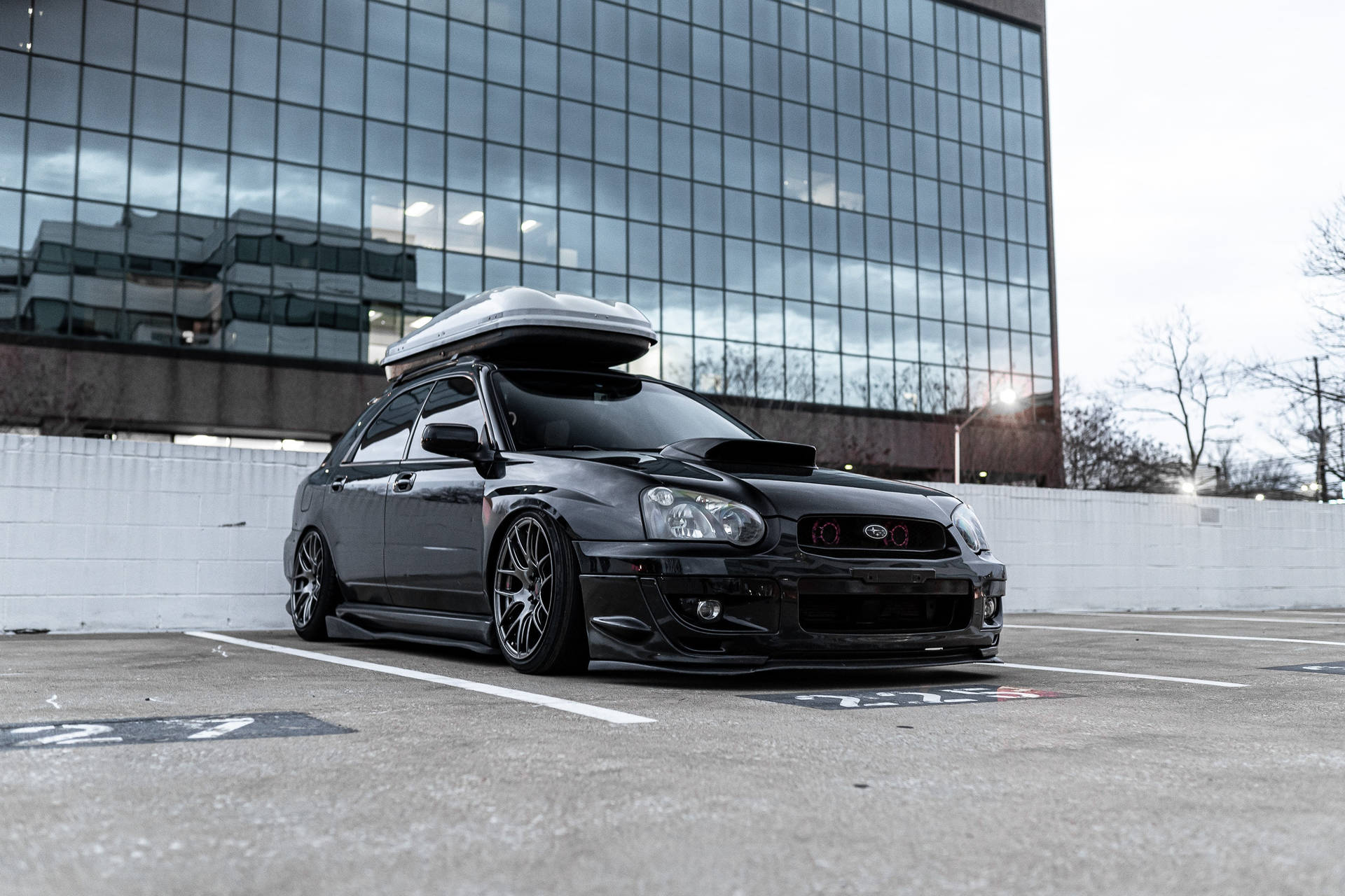 Schwarzer modifizierter Subaru mit Dachbox auf städtischem Parkplatz. — Schwarze Sportwagen Wallpaper