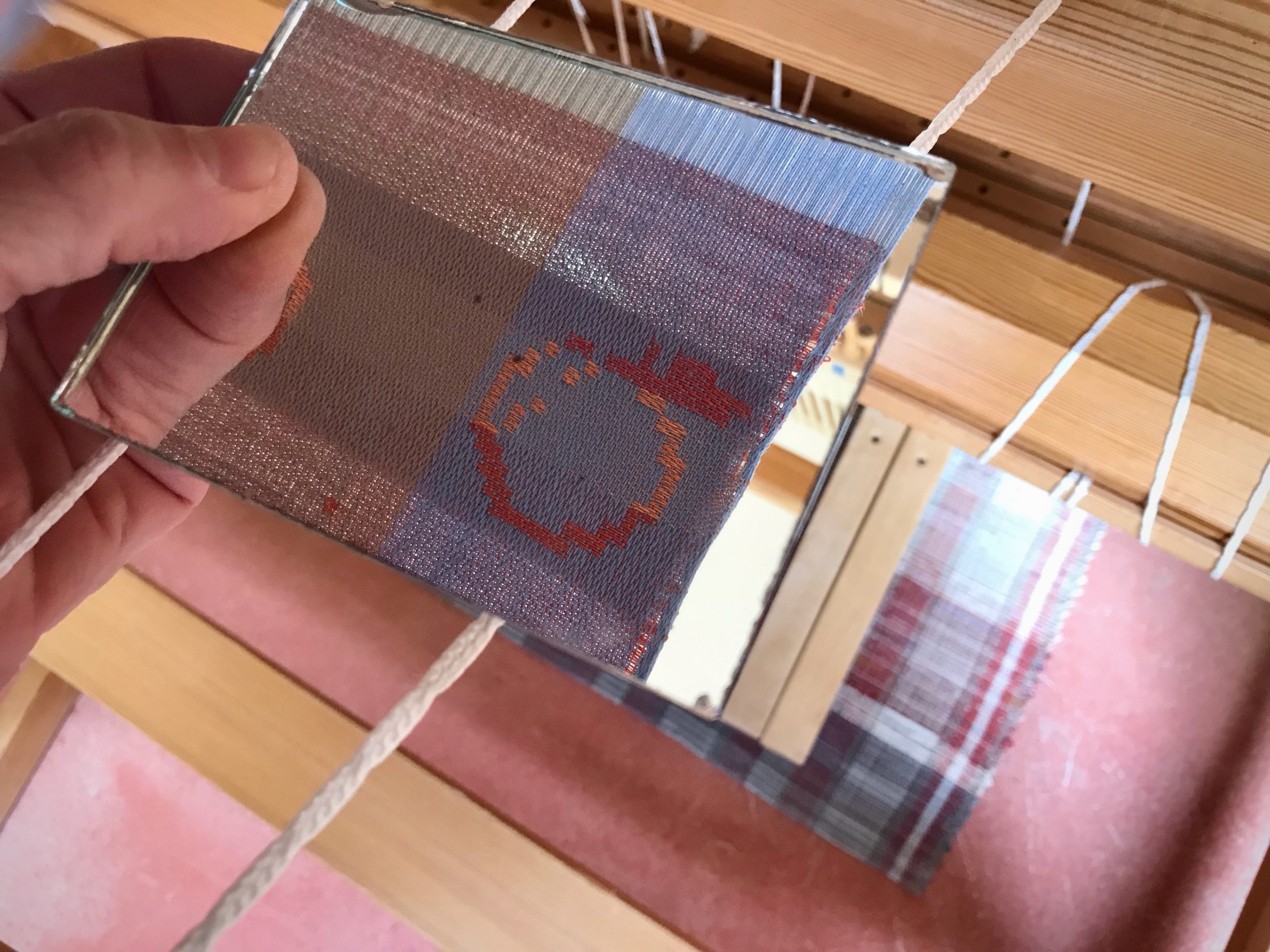 Mirror shows reversed side of drawloom fabric.