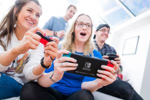 Portrait of a group of men and women playing video games on a Nintendo Switch console with Nintendo Pro and Joy Con wireless controllers, taken on March 7, 2017. (Photo by James Sheppard/Future via Getty Images)