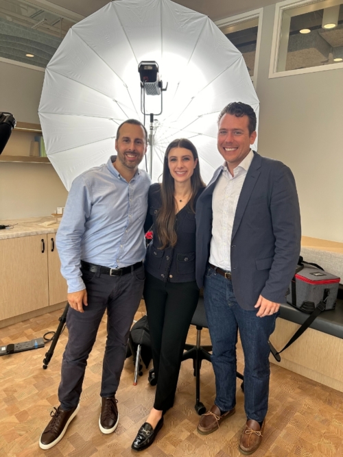 woman with two men standing in front of photography light