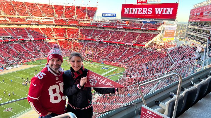 man and woman posed at levi's stadium after 49er win