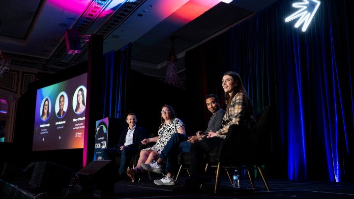 four people seated onstage at conference panel