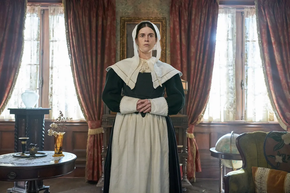 Woman dressed as puritan with a white cap and black dress in 'Ghosts' Season 4 Halloween episode