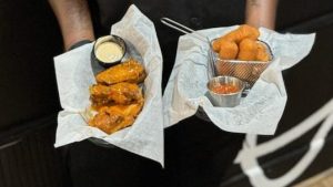 Corey Corey T. Smith holds plates of food made by his sister, Dominique Spence, who is head chef at his restaurant, One Bar + One Kitchen in Hartford. The siblings both learned to cook through their maternal grandmother. The restaurant has closed