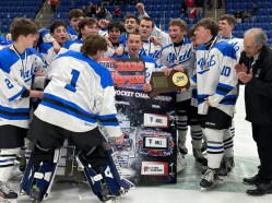hallhockeywins The Hall hockey team celebrates after goalie Matthew Bonner places the Hall sign in the championship spot on the bracket after Hall's 2-1 overtime win over E.O. Smith in the Division III hockey final at M&T Arena at Quinnipiac in Hamden Thursday night. (Photo by Lori Riley)
