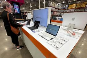 Apple_Mac_Price_Hikes__4357 FILE – A shopper looks over Apple MacBook laptops on display in a Costco warehouse on June 2, 2026, in Sheridan, Colo. (AP Photo/David Zalubowski, File)