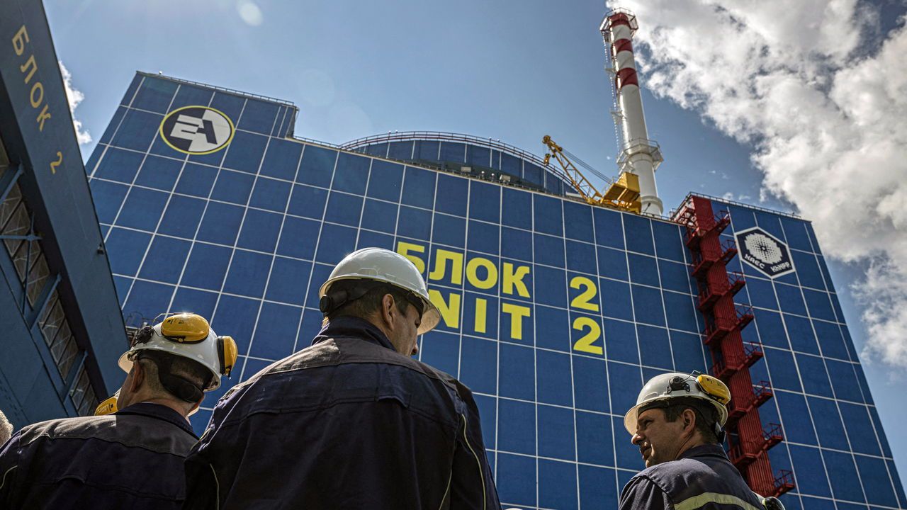 Employees stand in front of the second power unit of the Khmelnytskyi Nuclear Power Plant.