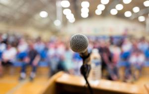 Image showing a microphone and blurred audience.