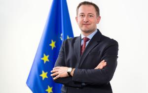 Christophe Hansen, European Commissioner for Agriculture and Food, standing in front of the European flag