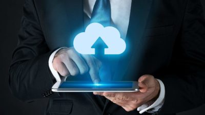 A man activates an arrow shooting up into a cloud sign on his phone, indicating share price movement in ASX tech shares