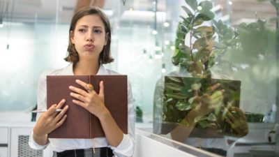 A businesswoman exhales a deep sigh after receiving bad news, and gets on with it.