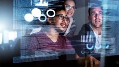 Three analysts look at tech options on a wall screen