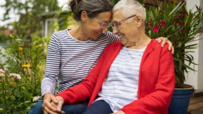 Senior woman with caregiver in the garden