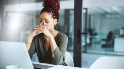 Shot of a young businesswoman looking stressed out while working in an office.