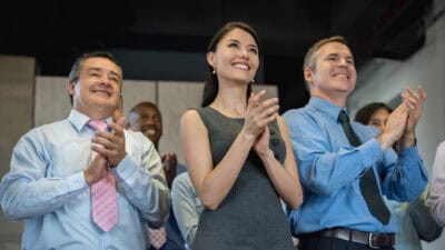 Successful group of people applauding in a business meeting and looking very happy.