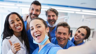 Six smiling health workers pose for a selfie.