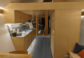 Interieur van de Pentagon-lodge bij Buytenplaets Suydersee in Nederland, met strakke houten afwerking.