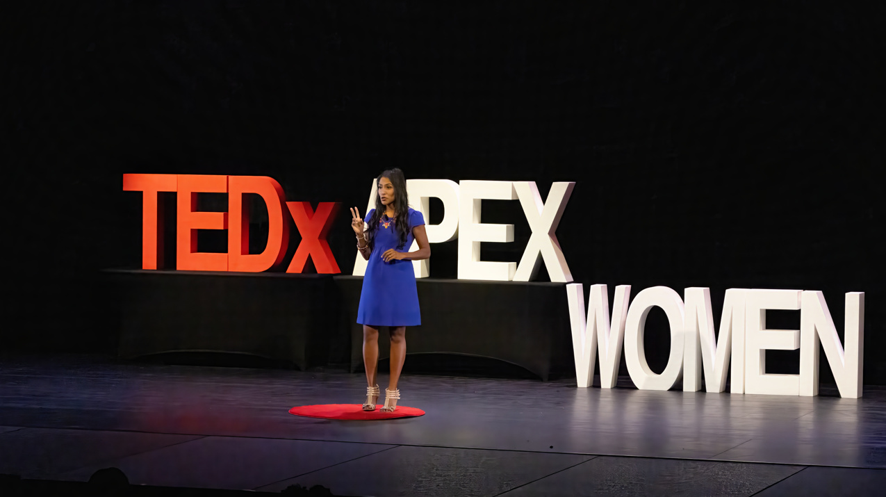 Krish O’Mara Vignarajah on stage at a TedX presentation.