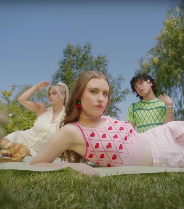 An image of three people in Cider clothing having a picnic.