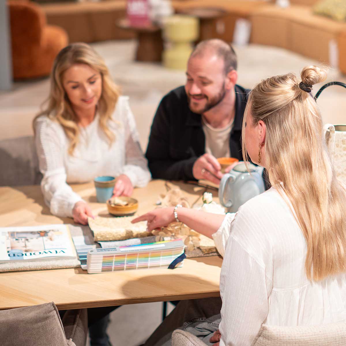 foto van drie personen die aan een eettafel zitten voor interieuradvies