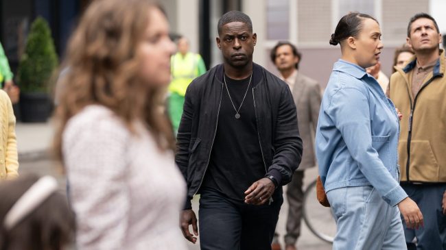 A man wearing all black and walking purposefully through a crowd; Sterling K. Brown in 'Paradise'