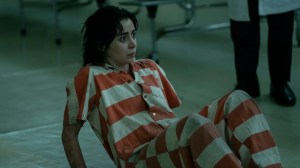 A woman on the ground wearing a white and orange striped jumpsuit; Cristin Milioti in 'The Penguin'