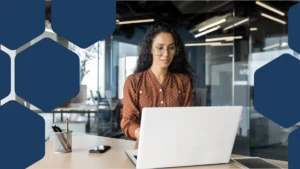 Woman with glasses at a laptop in an office