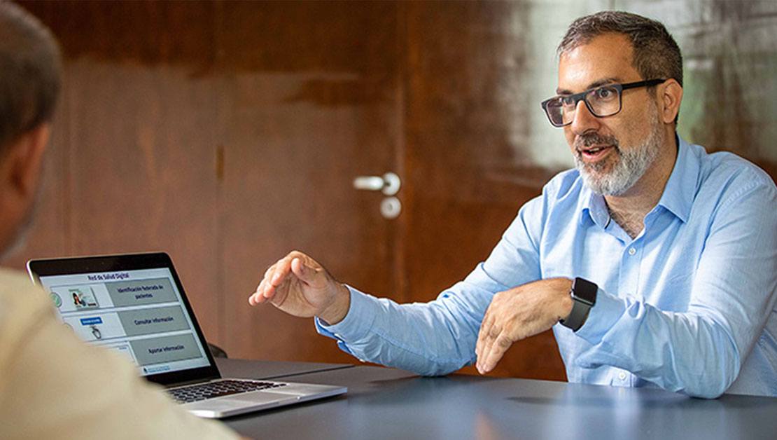 people discussing patient health data over a computer on a desk