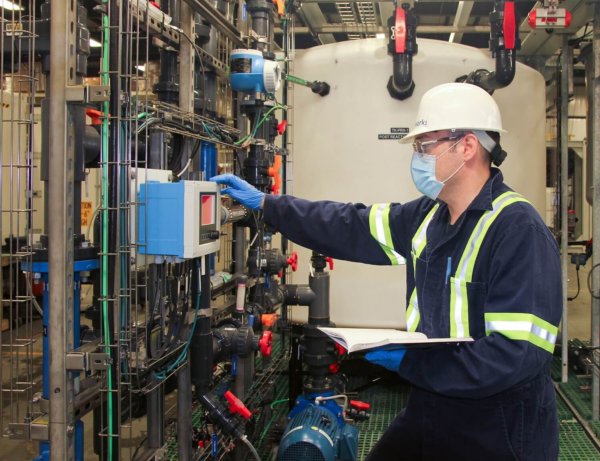 Photo of a Saltworks engineer inspecting a BrineRefine chemical reactor system used in the treatment of a specific ion of concern