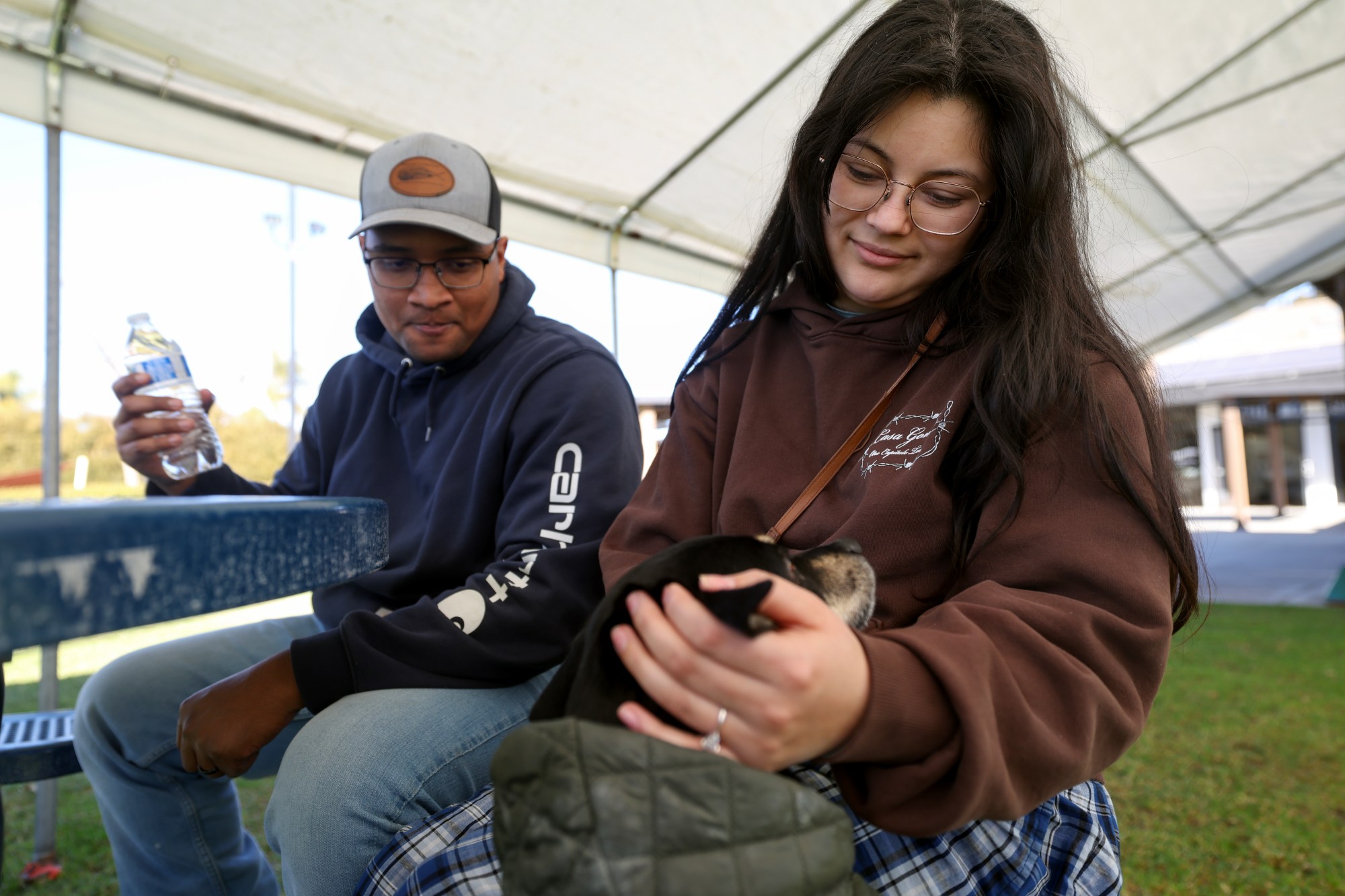 Lilac Fire evacuee Alyssa Valenzuela, holds Moose, as she and her husband Israel Valenzuela wait for word that the road block to their Bonsall home has been lifted while at an American Red Cross evacuation center set up at the Riverview Church in Bonsall on Tuesday, Jan. 21, 2025. Israel Valenzuela, a Navy sailor, said he was getting ready to go to work at the Navy base in San Diego around 5 am when a neighbor informed him about a brushfire. He and his wife Alyssa quickly packed up some belongings, their dog, and went to an evacuation center. (Hayne Palmour IV / For The San Diego Union-Tribune)