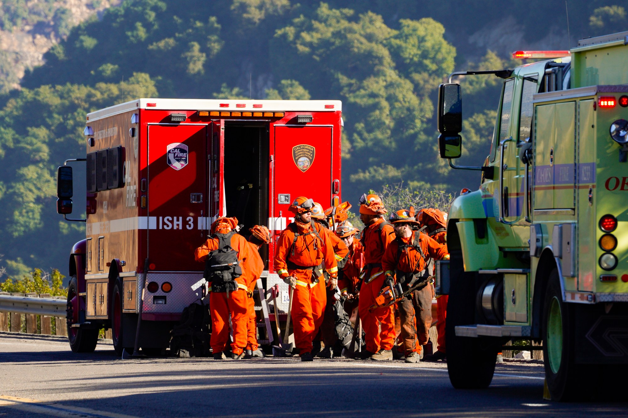 A hand tool crew prepares to work to extinguish remaining hot spots just off Old Highway 395 in Bonsall on Tuesday, Jan. 21, 2025. (Nelvin C. Cepeda / The San Diego Union-Tribune)