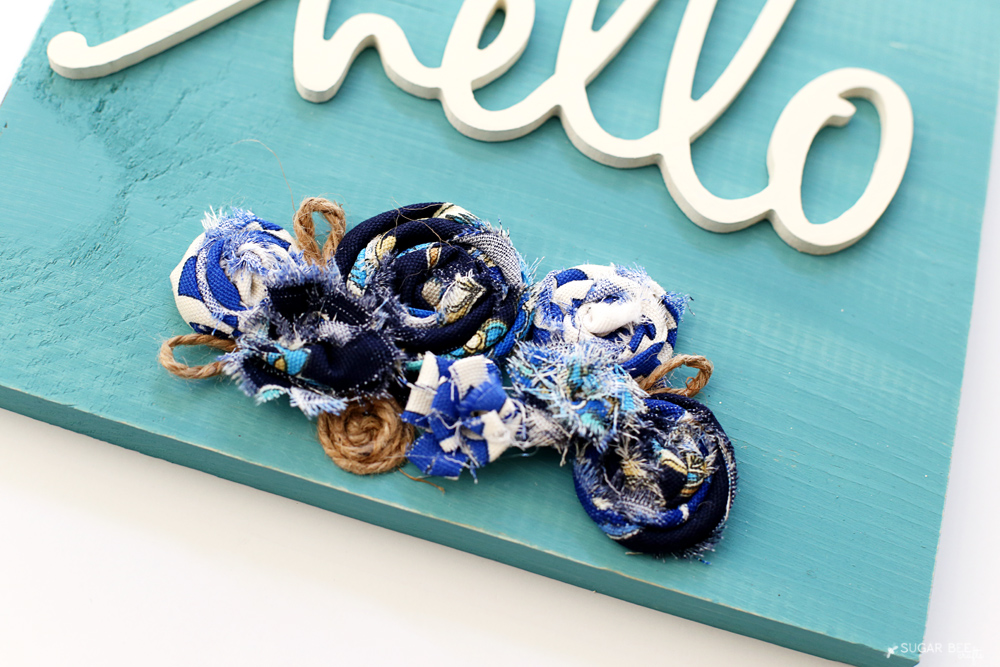 rolled-fabric-flowers-on-plaque-sign