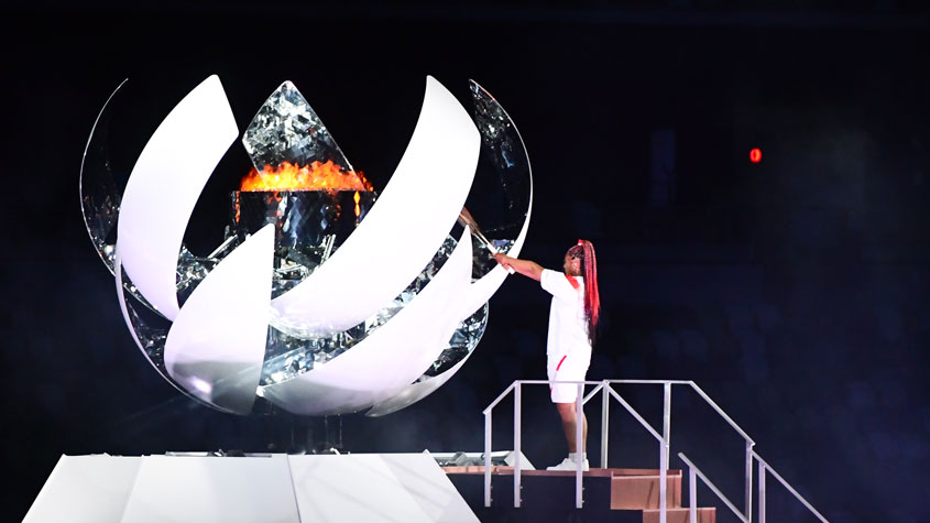 a female sportsman lighting the Olympic torch