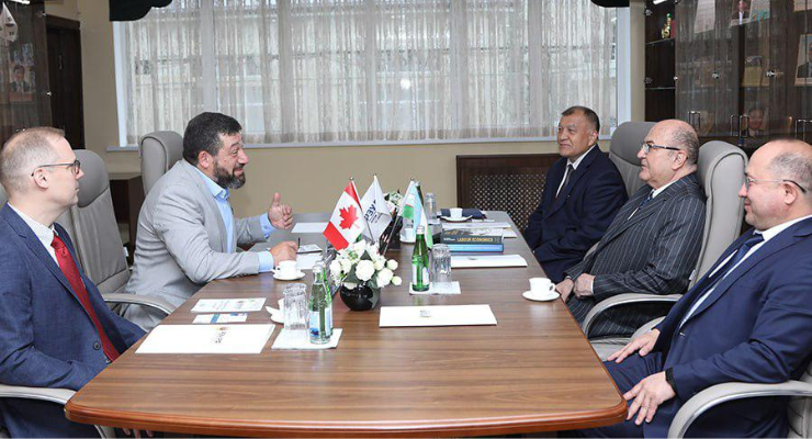 Five men sitting around a table wearing business professional suits