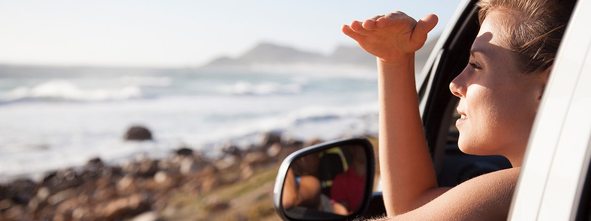 A woman enjoying the scenery form the window of her car